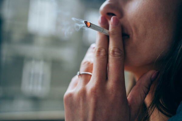 Mulher com cigarro na boca fumando