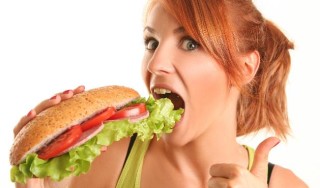 Mulher comendo um lanche após treinas - Foto: Getty Images