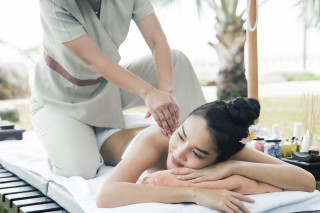 Mulher deitada recebendo massagem para aliviar a tensão