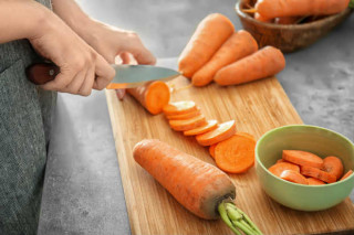 Mulher cortando cenoura - Foto: Shutterstock