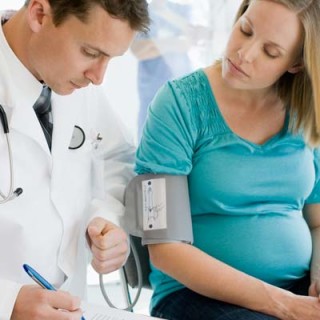 Médico aferindo a pressão de uma grávida - Foto Getty Images