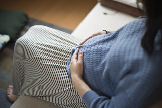 Mulher grávida sentada no sofá