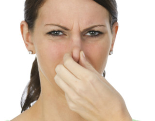 Mulher tampando o nariz para evitar cheiro ruim