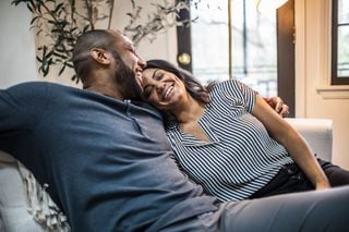 Casal feliz abraçado no sofá