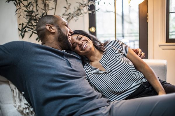 Casal feliz abraçado no sofá