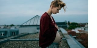 Mulher grávida no topo de um prédio