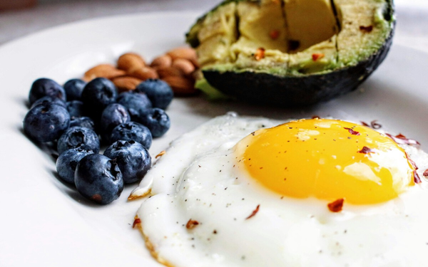 Imagem aproximada de ovo frito com frutas e grãos