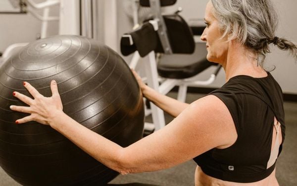 mulher segurando uma bola de pilates