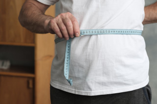 Homem medindo a circunferência da própria barriga
