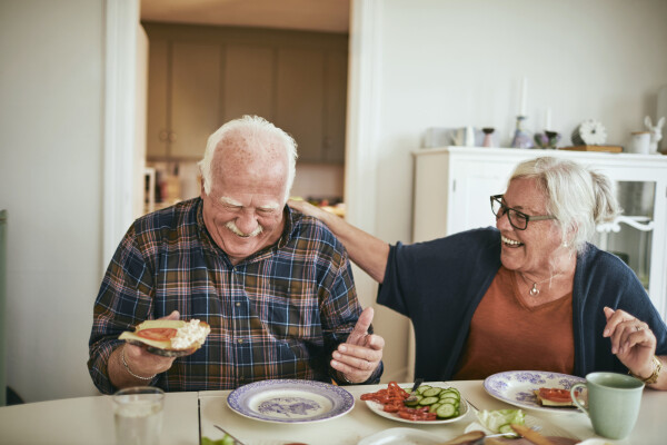 Casal de idosos comendo com ânimo