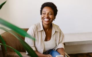 mulher sorrindo sentada no sofá