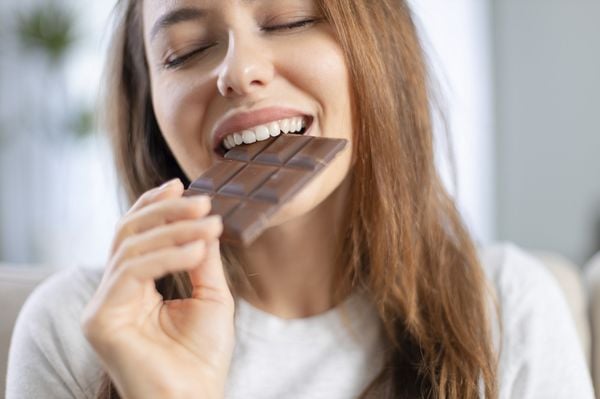 Mulher mordendo uma barra de chocolate