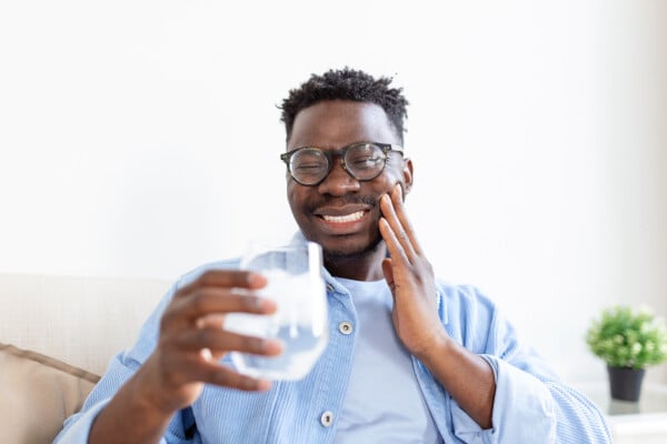 Homem negro sofrendo com dente sensível
