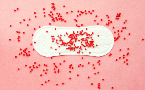 Absorvente com bolinhas vermelhas que simulam sangramento vaginal