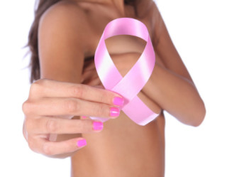 Mulher com câncer de mama na família mostrando laço rosa 