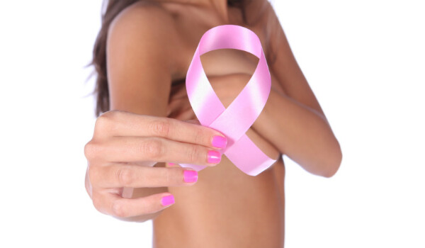 Mulher com câncer de mama na família mostrando laço rosa 
