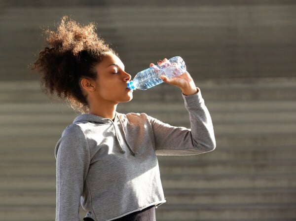 Mulher jovem tomando uma garrafa de água