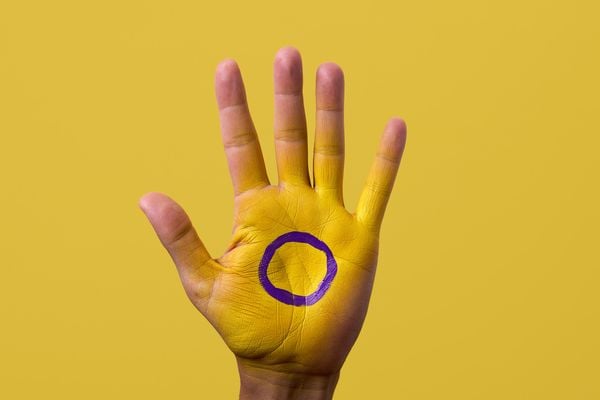 mão com a bandeira de pessoas intersexo