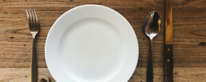imagem de um prato vazio com talheres ao lado