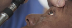 Homem tendo o olho examinado por um médico