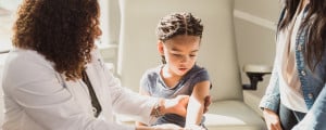 médica examinando o braço de uma criança
