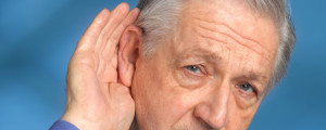 Homem com a mão na orelha tentando ouvir melhor