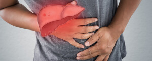 Rapaz de camiseta cinza com as mãos na barriga e a ilustração de um fígado sobre as mãos