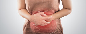 Mulher com síndrome do intestino irritável, com as mãos sobre a barriga com um desenho do intestino