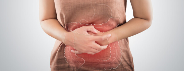 Mulher com síndrome do intestino irritável, com as mãos sobre a barriga com um desenho do intestino