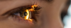 Foto aproximada de olho, com um feixe de luz iluminando a retina