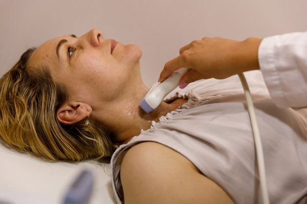 Mulher realizando exame de ultrassom no pescoço