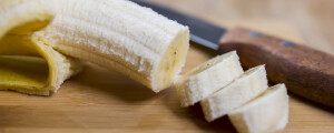 Banana cortada em rodelas em cima de mesa de madeira