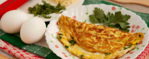 Prato branco com omelete e dois ovos ao lado
