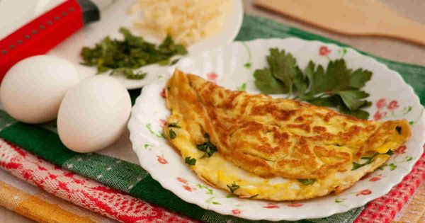 Prato branco com omelete e dois ovos ao lado