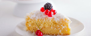 Imagem de um bolo de aipim com coco e cereja em cima