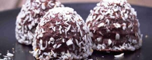 Três trufas crudívoras cobertas de coco ralado.