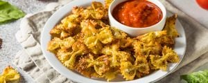 Prato de macarrão farfalle com uma tigela de molho de tomate dentro