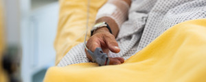 Pessoa deitada em maca de hospital em lençol amarelo
