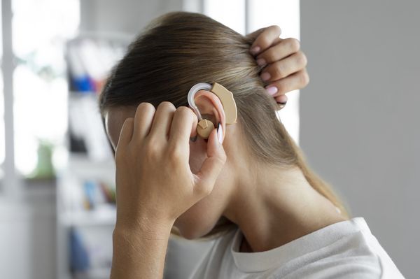 Mulher usando aparelho de ouvido