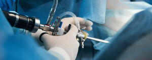 médico com um cistoscopio na mão na frente de uma paciente deitada