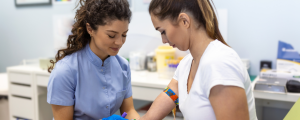 Enfermeira coleta sangue de uma mulher jovem em um laboratório