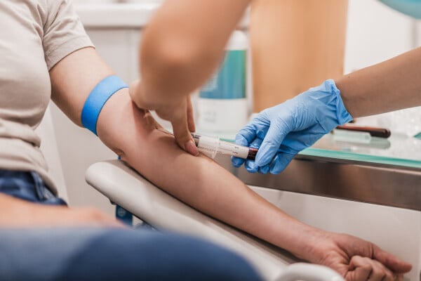 Imagem aproximada de enfermeira coletando sangue de uma paciente para realização de exames