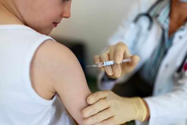 médico aplicando vacina no braço de uma criança