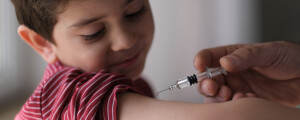 Garoto recebendo vacina no braço