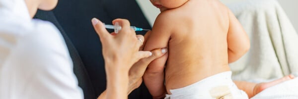 Close de bebê sendo vacinado no braço